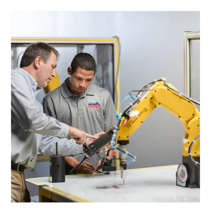 Apprenticeship instructor and student looking at machine
